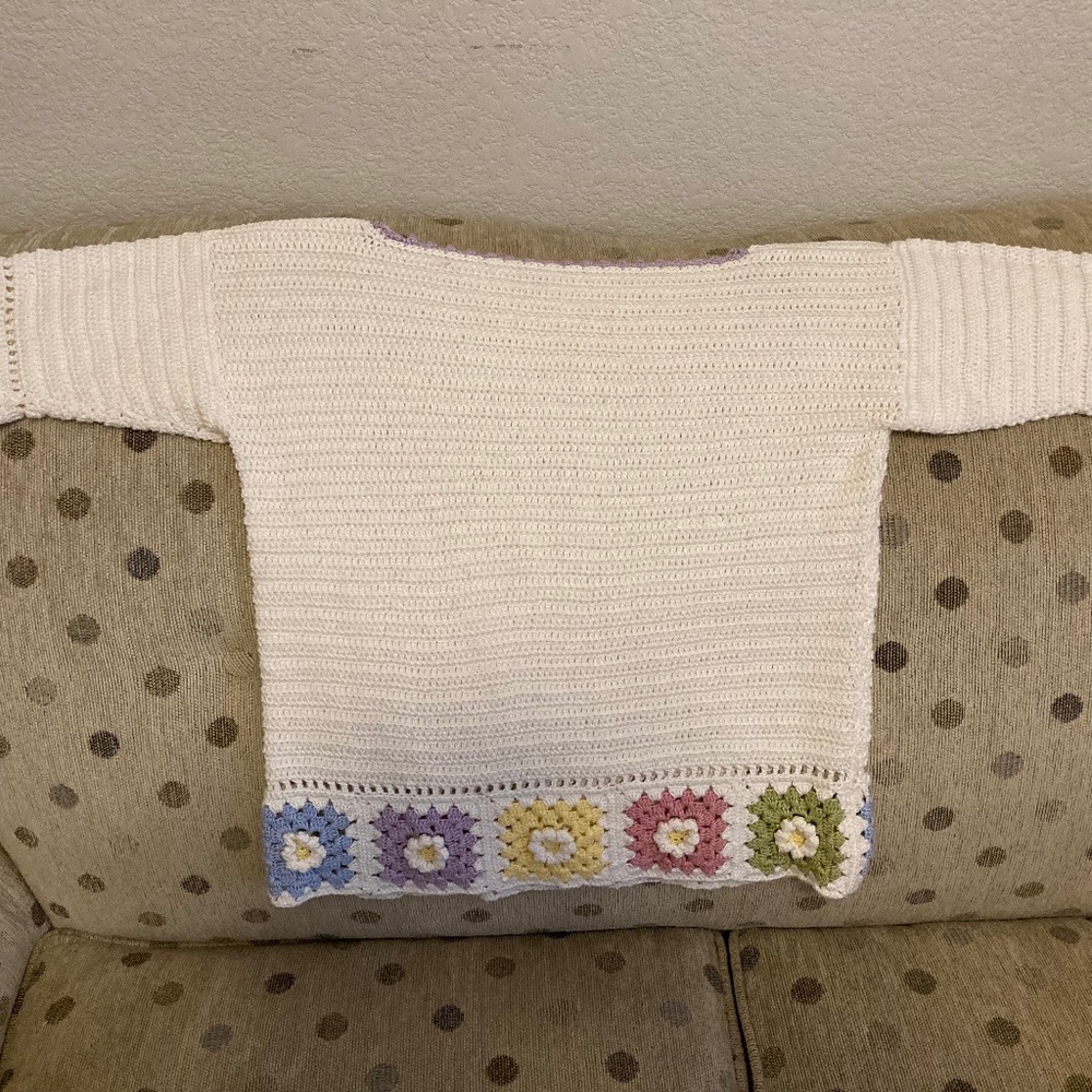 Crocheted sweater with daisy accents
